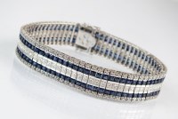Lot 260 - An 18ct white gold diamond and sapphire line...