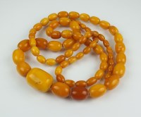 Lot 265 - A graduated amber bead necklace, comprising...