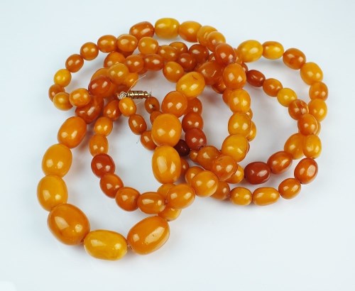 Lot 267 - A graduated amber bead necklace, comprising;...