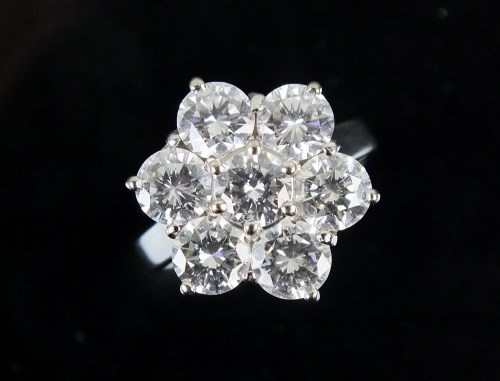 Lot 301 - An 18ct white gold seven stone diamond floral...