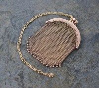 Lot 134 - A yellow metal mesh purse, with attached chain,...