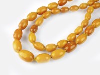 Lot 258 - A two strand graduated amber bead necklace,...