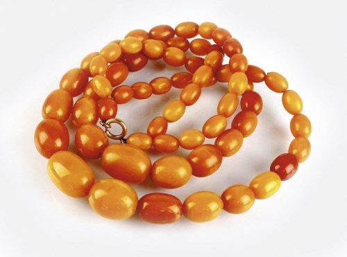 Lot 259 - A graduated two strand amber bead necklace,...