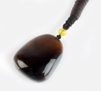 Lot 260 - A Burmese amber pendant, of polished form...