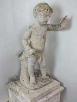 Lot 339 - A composite stone figure of a cherub holding a...