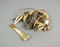 Lot 392 - An African warthog tooth necklace suspended...