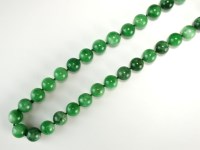 Lot 168 - A mottled green and white jadeite bead...