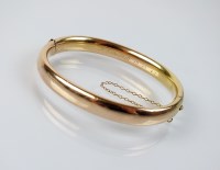 Lot 163 - A yellow metal hollow hinged bangle, with...