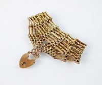Lot 196 - A yellow metal seven bar gate link bracelet,...
