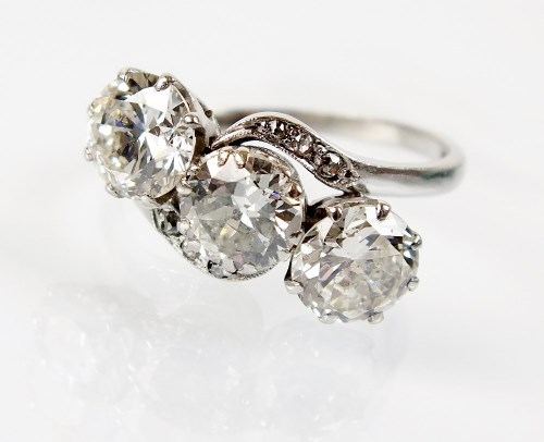 Lot 241 - A three stone graduated diamond crossover ring,...