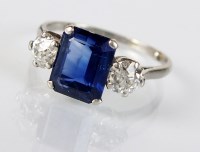 Lot 243 - A three stone sapphire and diamond ring,...