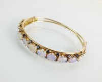 Lot 98 - An opal and sapphire hinged bangle, designed...