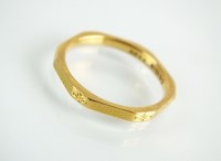 Lot 132 - A 22ct gold faceted wedding band, with engine...