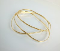 Lot 163 - Three yellow metal bangles, with engraved...