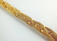 Lot 201 - A yellow metal three strand woven bracelet,...