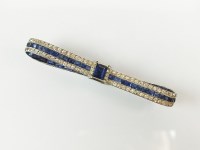 Lot 246 - An Art Deco diamond and sapphire stylised bow...