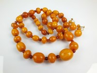 Lot 253 - A graduated amber bead necklace, comprising...