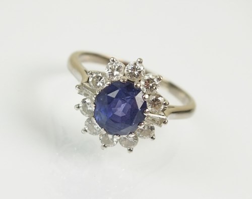 Lot 261 - An 18ct white gold sapphire and diamond...