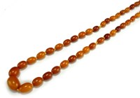 Lot 128 - A graduated amber bead necklace, comprising...