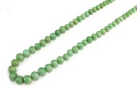 Lot 129 - A graduated jade bead necklace, comprising 102...