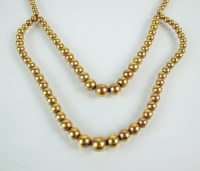 Lot 104 - A yellow metal graduated bead necklace, the...