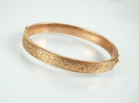 Lot 122 - A 9ct rose gold hollow hinged bangle, with...