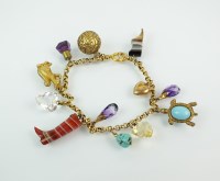 Lot 125 - A yellow metal bracelet with attached charms,...