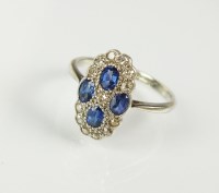 Lot 193 - A diamond and sapphire panel cluster ring,...