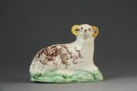 Lot 390 - An English creamware model of a recumbent lamb,...