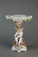 Lot 41 - A Dresden porcelain base modelled as Cupid,...