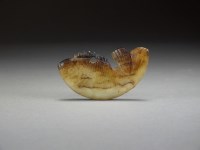 Lot 152 - A Chinese pale green and brown jade fish...