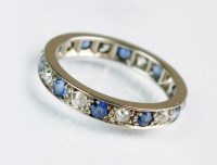 Lot 215 - A sapphire and diamond eternity ring, designed...
