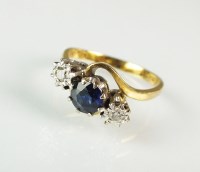 Lot 231 - An 18ct gold three stone sapphire and diamond...