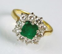 Lot 255 - An 18ct gold emerald and diamond cluster ring,...