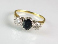 Lot 279 - A three stone sapphire and diamond ring,...