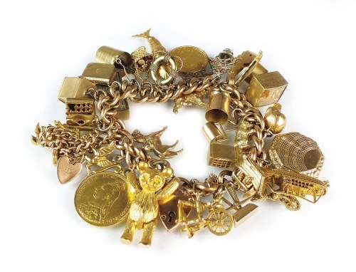 Lot 304 - A yellow metal hollow curb link charm bracelet,...