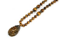 Lot 405 - A Chinese tiger's eye and silver pendant...