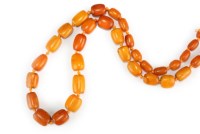 Lot 406 - A graduated amber bead necklace, comprising...