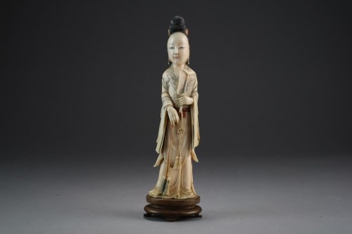 Lot 454 - A Chinese carved and stained ivory figure of a...