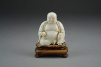 Lot 463 - A Chinese carved ivory figure of a seated...