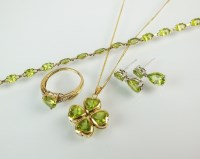 Lot 176 - An 18ct gold four stone peridot pendant,...