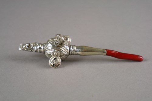 Lot 17 - A white metal mounted rattle, with whistle,...