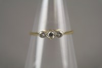 Lot 77 - A three stone graduated diamond ring, the...