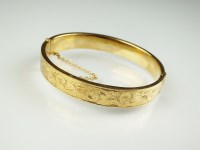 Lot 190 - A 9ct gold hinged bangle, with engraved bright...