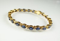Lot 230 - A sapphire and diamond line bracelet, designed...