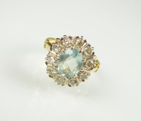 Lot 233 - An aquamarine and diamond oval cluster ring,...