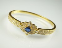 Lot 234 - A sapphire and diamond hinged bangle, designed...