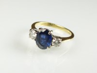 Lot 235 - An 18ct gold three stone sapphire and diamond...