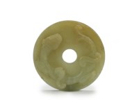 Lot 42 - A Chinese pale green jade 'chilong' disc, Bi...