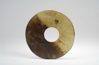 Lot 44 - A Chinese grey and russet jade disc, Bi...